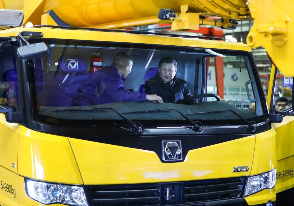 2017年12月12日，习近平在江苏徐州徐工集团坐进刚下线的XCA220型全地面起重机驾驶室，向技术人员详细询问起重机的性能、产量、价格等。（图源：新华社）