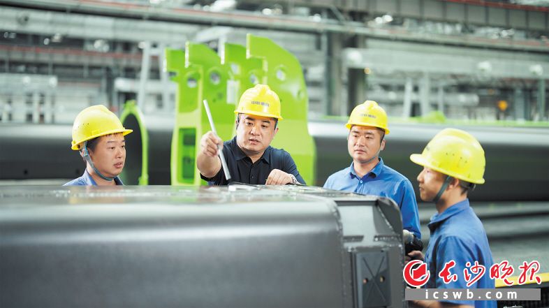 龙卫国（左二）劳动节在调试4000吨全地面起重机。长沙晚报通讯员 李家宇 供图