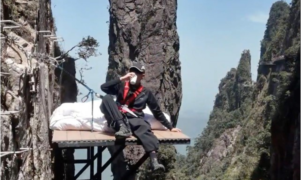 A tourist sips coffee on the cliff bed. Photo: Screenshot from CNR