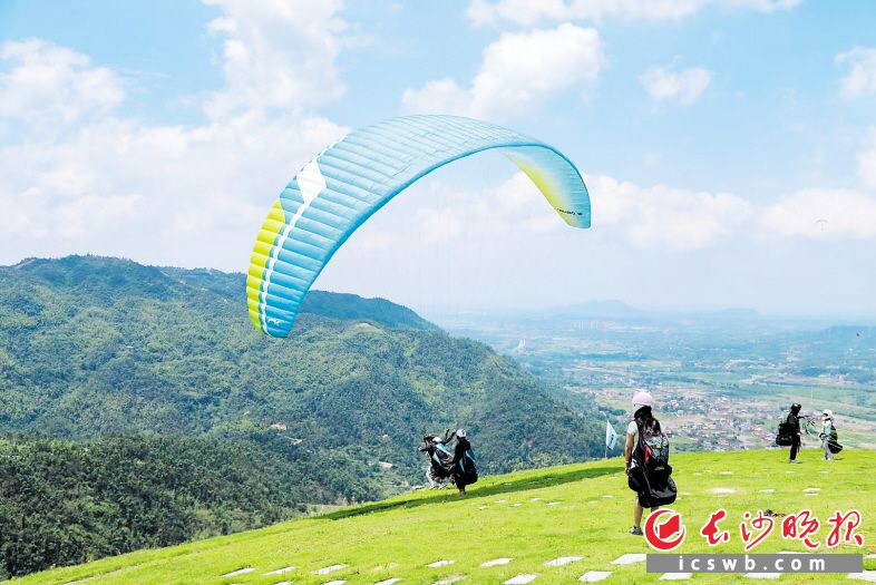在黑麋峰滑翔伞基地，游客可以沿着山脊飞行，欣赏连绵不断的群山，也可以低空掠过湖面，感受水波荡漾的灵动之美。长沙晚报通讯员 朱小勇 供图
