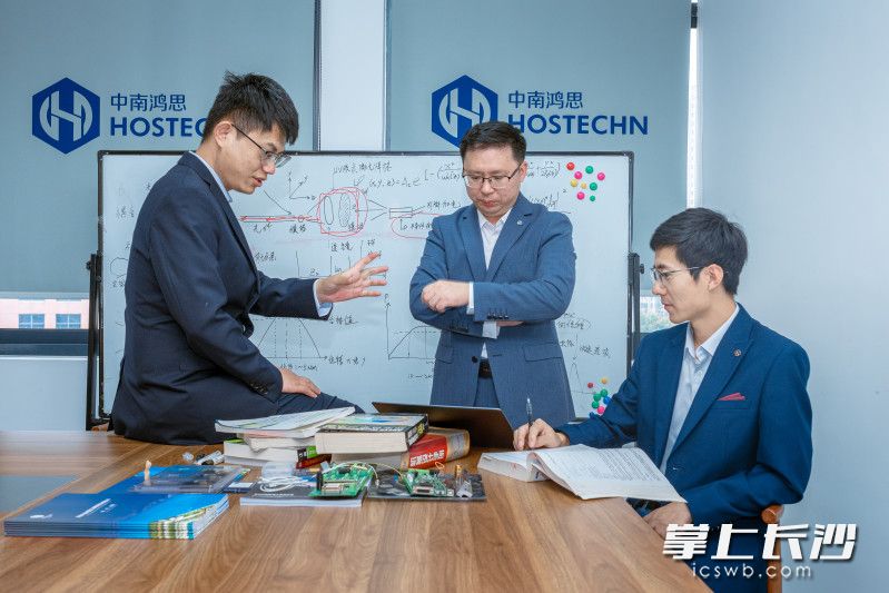 唐佳（右）正与团队探讨技术突围。