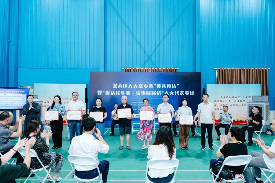 在活动现场为居民议事委员会议事员颁发聘书。