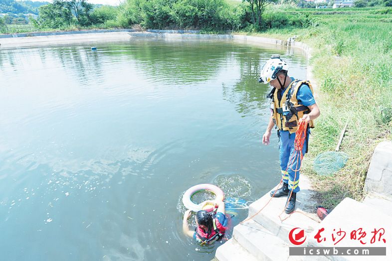 　　长沙县蓝天救援队队员给孩子们在池塘边上“救命课”。　　长沙晚报全媒体记者 舒元臻 摄