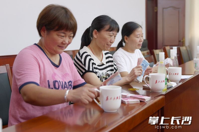 村民拿到分红，喜笑颜开。
