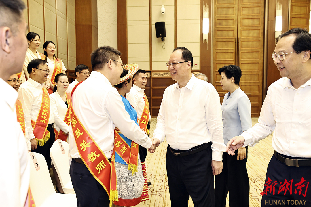 毛伟明与参会代表握手。