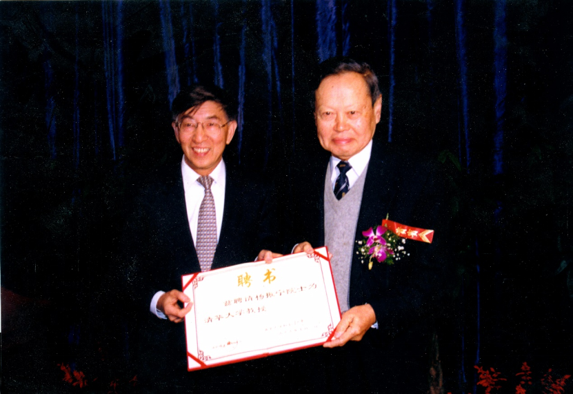 1999年，杨振宁（右）从时任清华校长王大中（左）手中接过清华大学聘书。（清华大学供图）