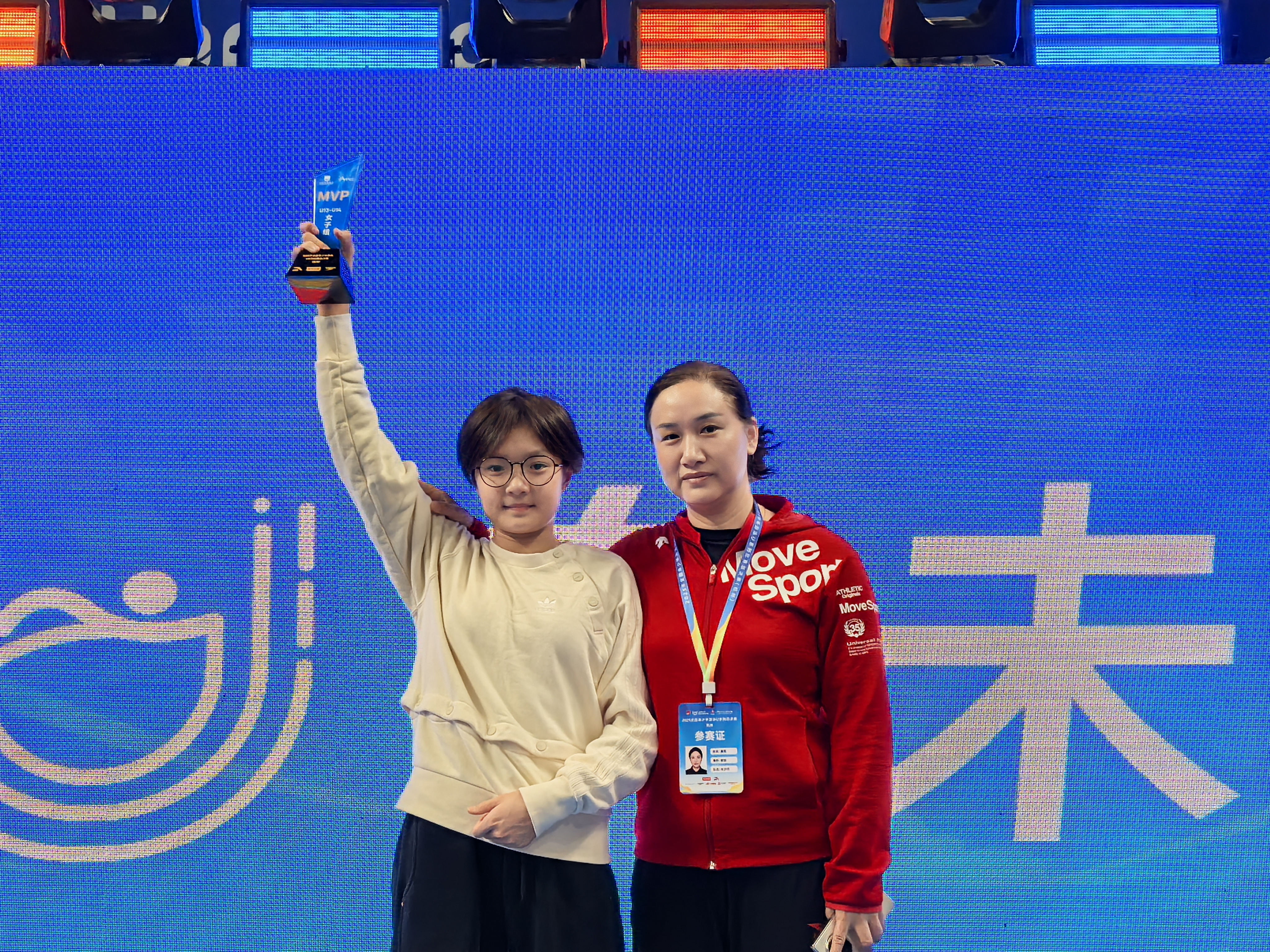 胡芊翯（左）赛后领取MVP奖杯，右为龚茜教练。
