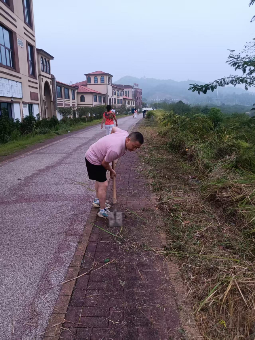 周智勇带领居民在河堤清除杂草。 周智勇带领居民在河堤清除杂草。