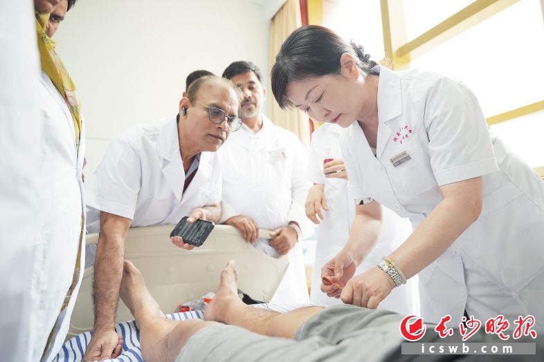Pakistani doctors carefully observe and learn from TCM experts' treatment techniques.