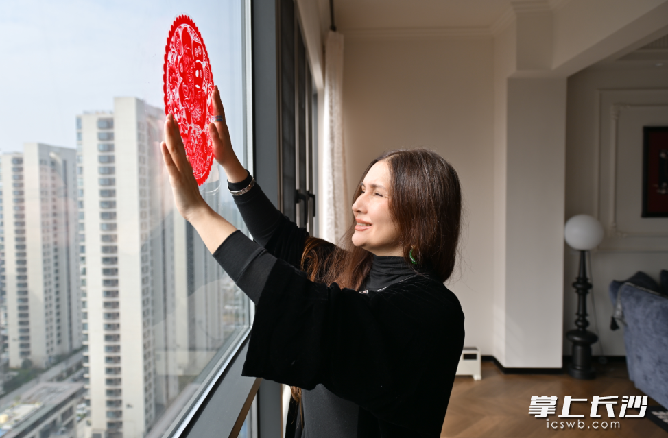 马克萨特的妻子在贴窗花。