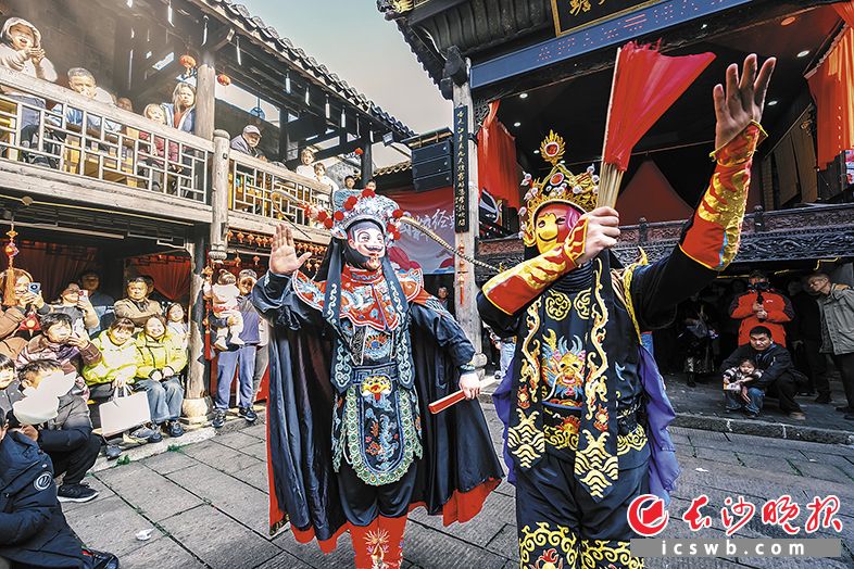 变脸表演中,王启发(左)与师弟亮出“哪吒”和“表情包”等脸谱,获得观众喜爱。 变脸表演中,王启发(左)与师弟亮出“哪吒”和“表情包”等脸谱,获得观众喜爱。