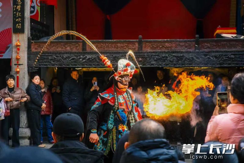 王启发在表演喷火绝活。 王启发在表演喷火绝活。