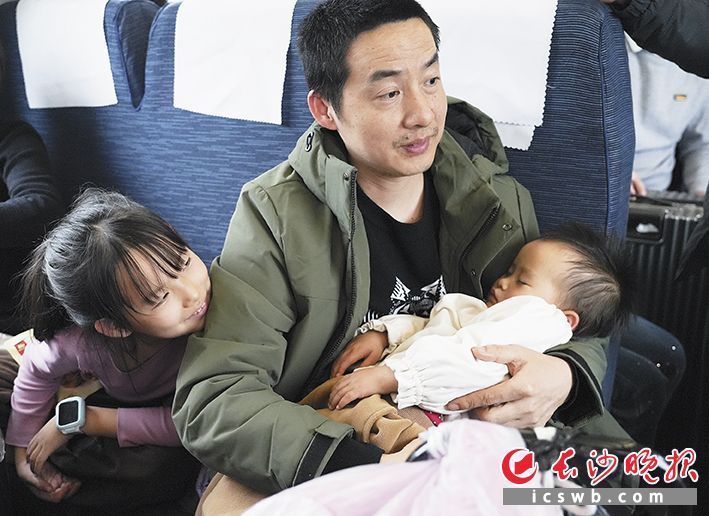 一位家长带着才2岁的小孩乘坐绿皮火车。本版摄影 长沙晚报全媒体记者 邹麟