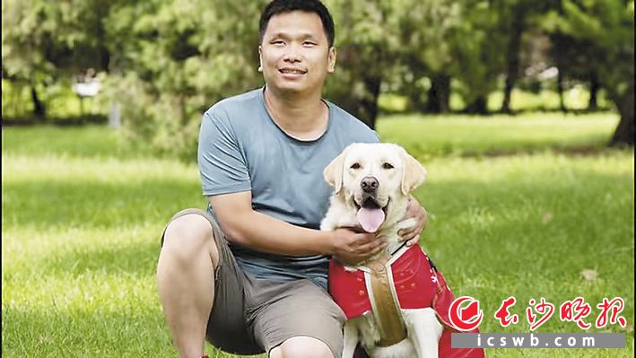 虽然看不见世界，汪涛还是希望通过拍摄视频，让世界看见自己。图为汪涛和导盲犬叮当。受访者供图