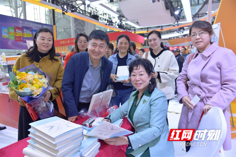 ▲余艳和等待其签名的读者。 ▲余艳和等待其签名的读者。