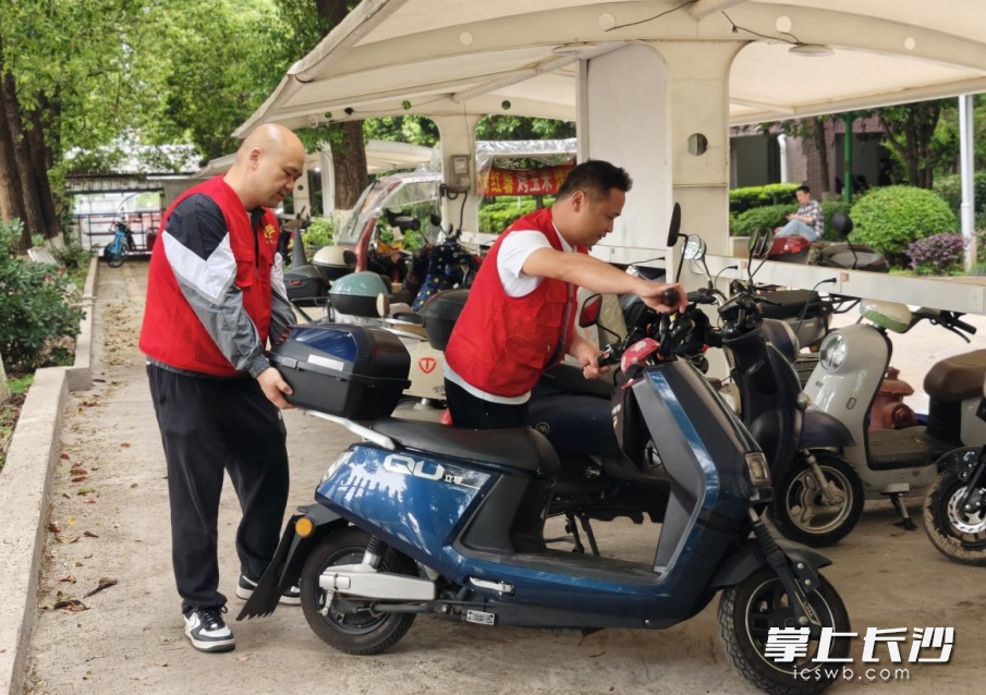 社区网格员周全（左一）、陈威正在小区规范电动车停放。均为长沙县泉塘街道供图