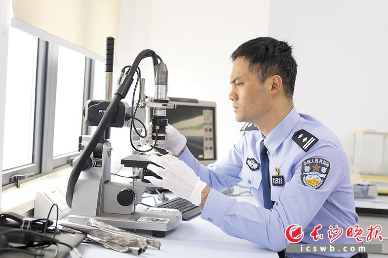许斌在实验室里查看物证痕迹。长沙晚报全媒体记者 尹昊天 摄