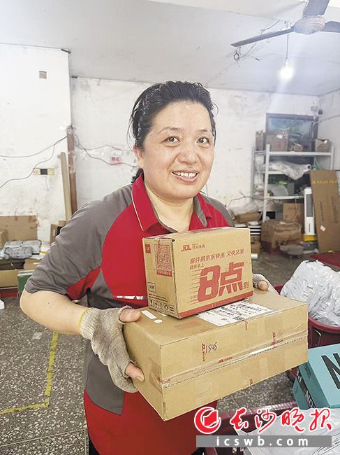 即将退休的“快递大姐”彭庆伟站好最后一班岗。 长沙晚报全媒体记者 李金 摄