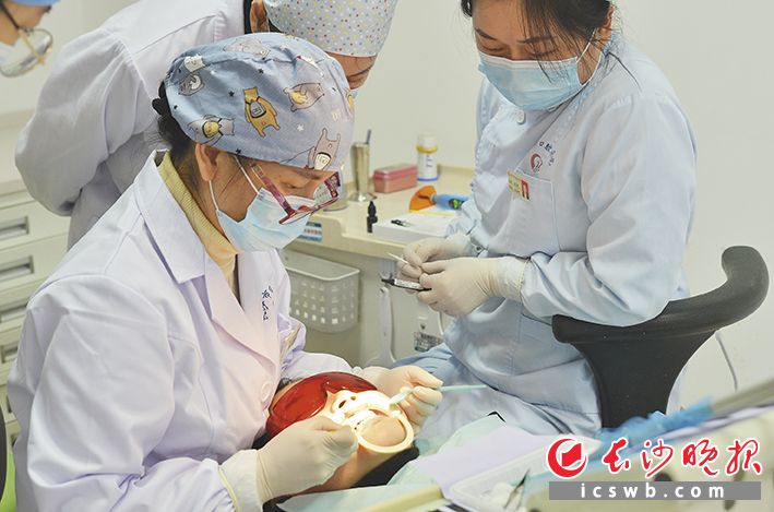 长沙市口腔医院友谊路院区口腔正畸科的医护人员在为正畸患者佩戴矫治器。