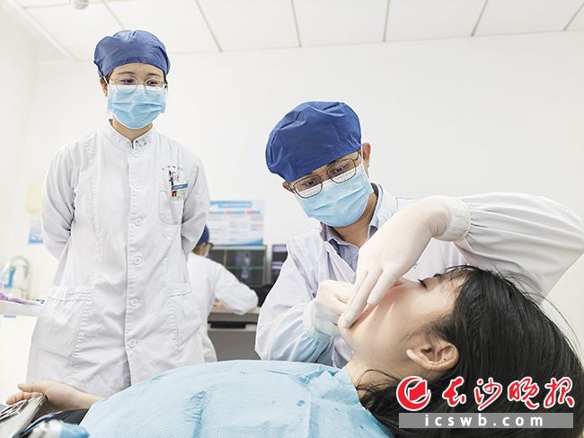 医护人员在为正畸患者进行邻面去釉治疗。均为医院供图