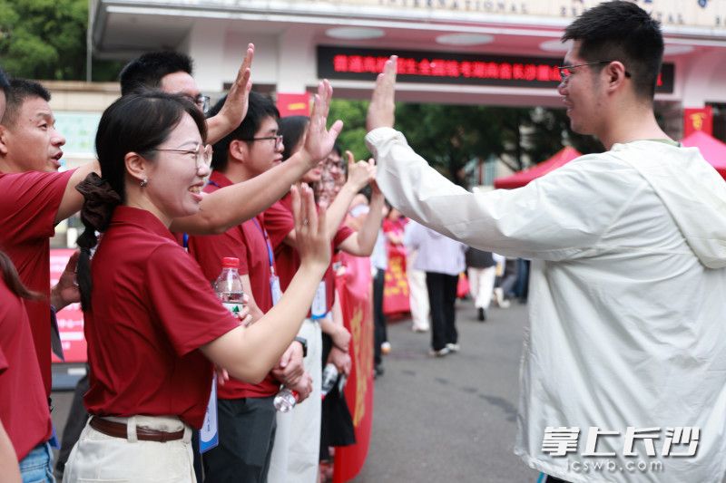 麓山国际实验学校考点外，老师们与考生击掌加油。长沙晚报全媒体记者 张炎炎 通讯员 唐婉欣摄影报道