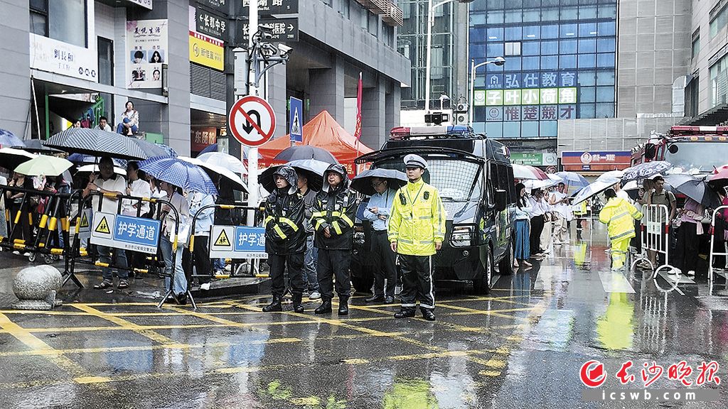 6月8日下午，民警雨中在长郡中学考点外维持秩序。  长沙晚报全媒体记者 张炎炎 摄