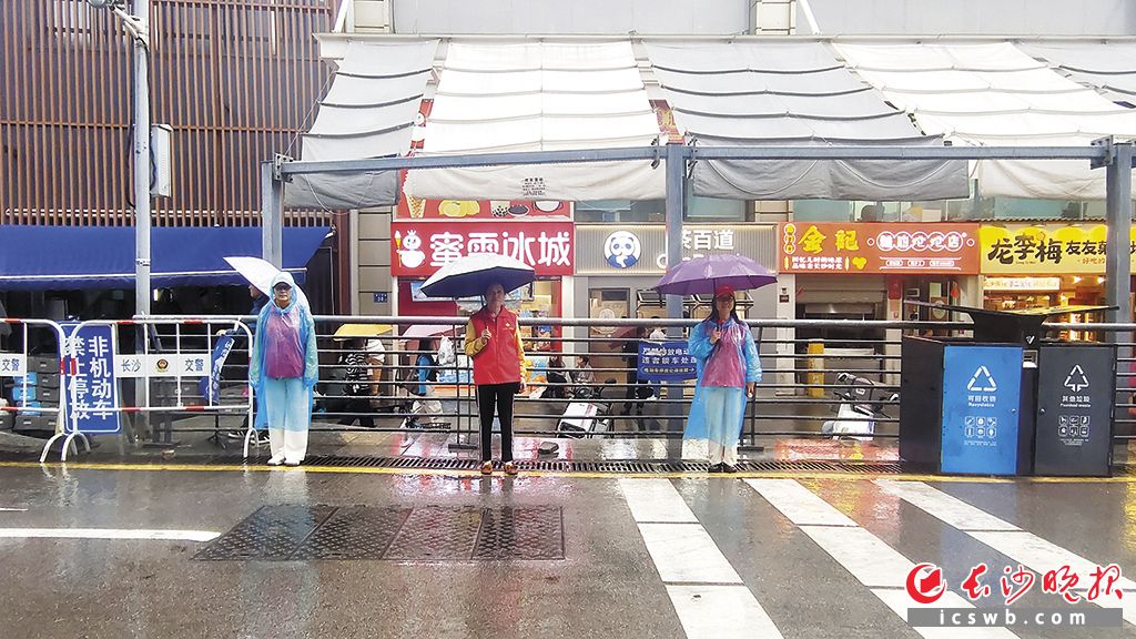 社区志愿者们雨中坚守岗位，确保考生赴考通道顺畅。 长沙晚报全媒体记者 张炎炎 摄