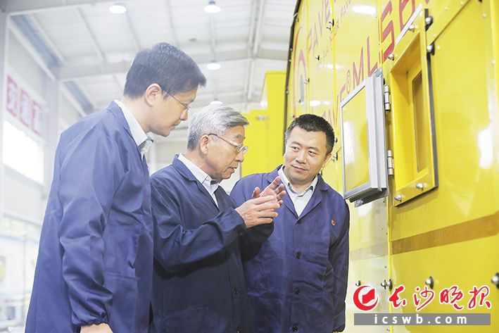 中国工程院院士、长沙理工大学教授郑健龙（中）在工程车前和团队成员交流。长沙晚报全媒体记者 陈卓 摄