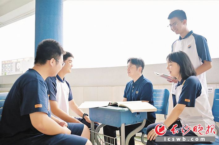 课余间隙，伍果平老师喜欢坐在教室外，跟学生答答疑聊聊天。长沙晚报通讯员 范嘉树 摄