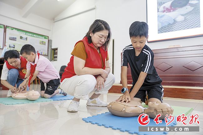 手把手指导亲子家庭进行心肺复苏操作。长沙晚报全媒体记者 邓迪 摄