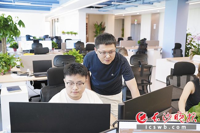 姚雪峰（右）和团队成员在核对项目运行数据。长沙晚报全媒体记者 刘攀 摄