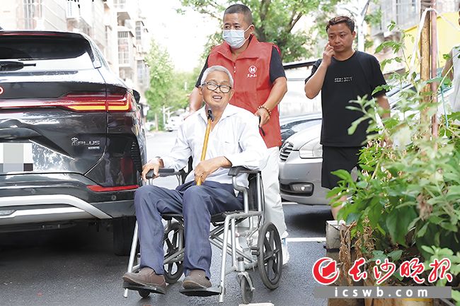 8月11日下午，张大爷血液透析结束后，养老护理员刘先生推着轮椅护送他回家。 长沙晚报全媒体记者 李茂健 摄