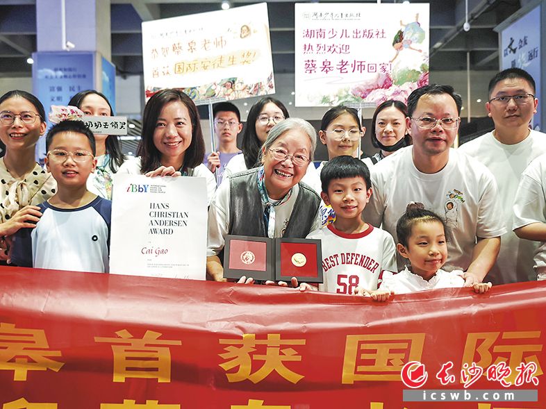 乘高铁回长的“宝藏奶奶”蔡皋（中）与迎接她的读者一起合影。长沙晚报全媒体记者 柳静芸 摄