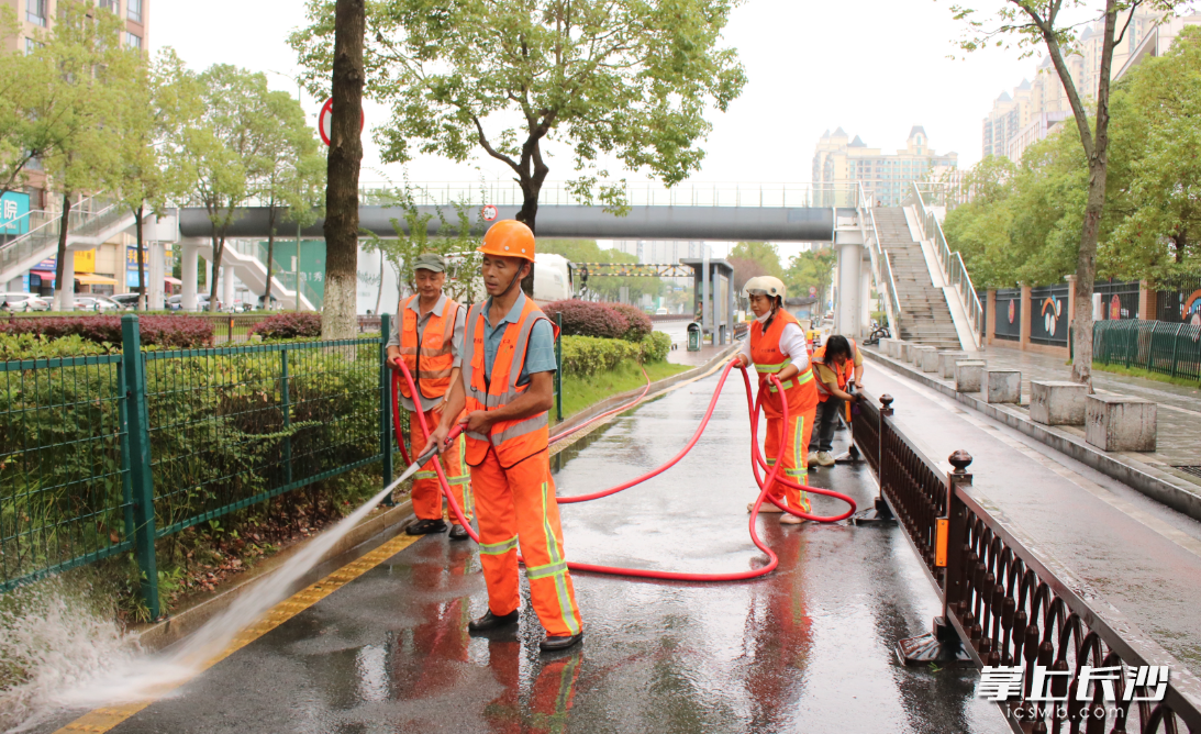 环卫工人在特立路上清洗路面、擦拭道路护栏。星沙时报记者 莫婷 摄