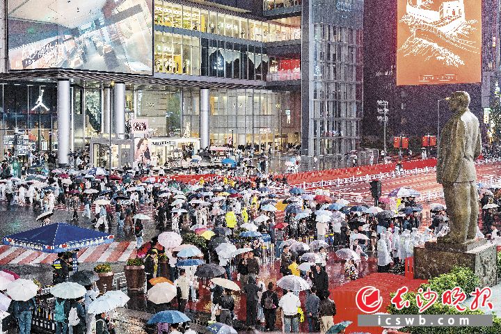 国庆假期前几日，星城细雨绵绵，却挡不住滚滚人流。五一广场、黄兴南路步行商业街等地人头攒动，游客撑伞而行，打卡夜景、品尝美食，节日氛围浓厚。 长沙晚报全媒体记者 周数邑 摄